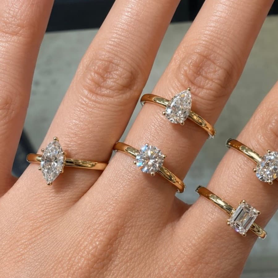 Gold solitaire rings worn on hand